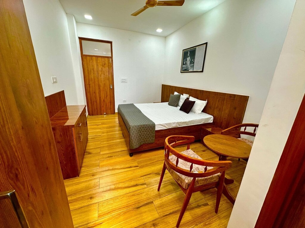 Modern hotel room with wooden furniture and a cozy bed.