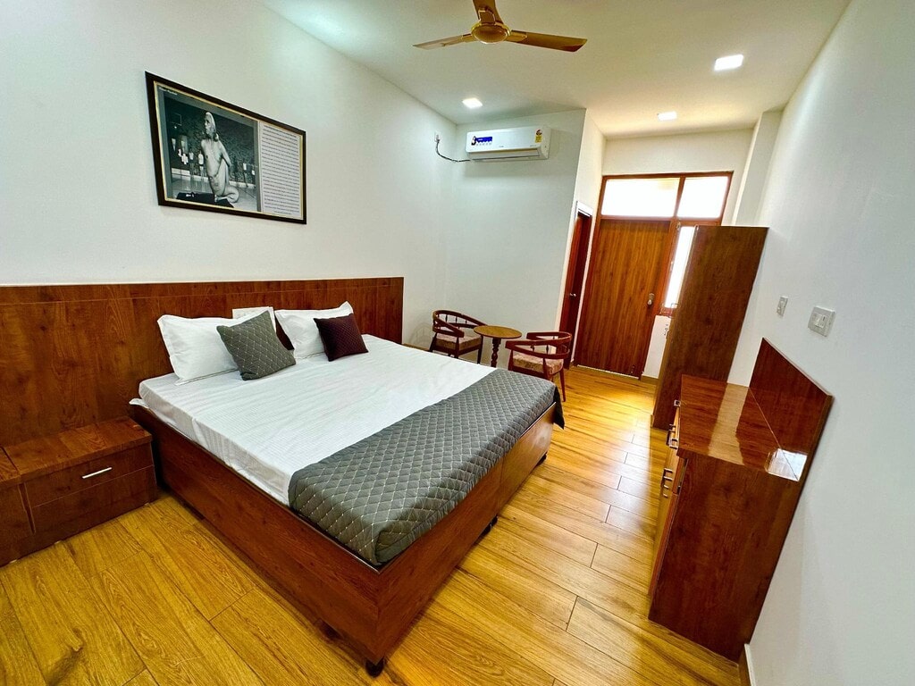 Modern hotel room with wooden furniture and a large bed.